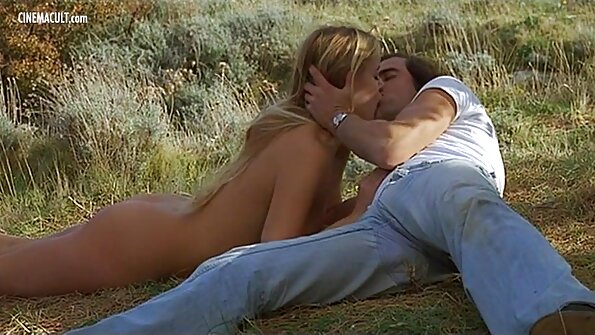 Tünd cizgiləri olan sinəli cazibədar qadın stolun üstündə çılpaq vəziyyətdədir